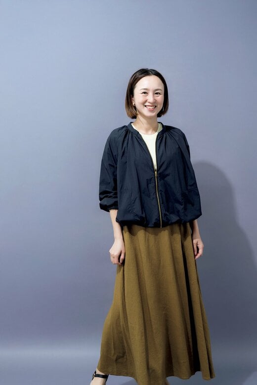 ネイビーのブルゾンを着て立つ女性