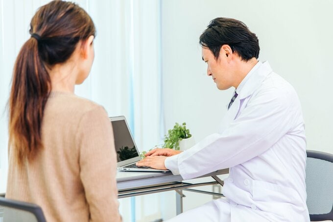 診察室で、医師が女性を診察している様子のイメージ画像