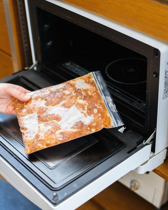 電子レンジに甘辛豚肉を入れる