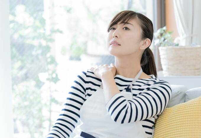 肩をおさえる女性