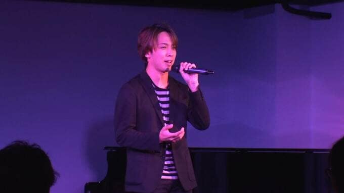 マイクを持って話す男性