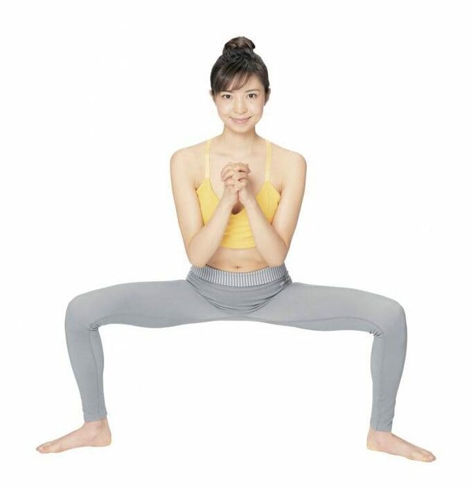 手を合わせたまま腰を落とす女性