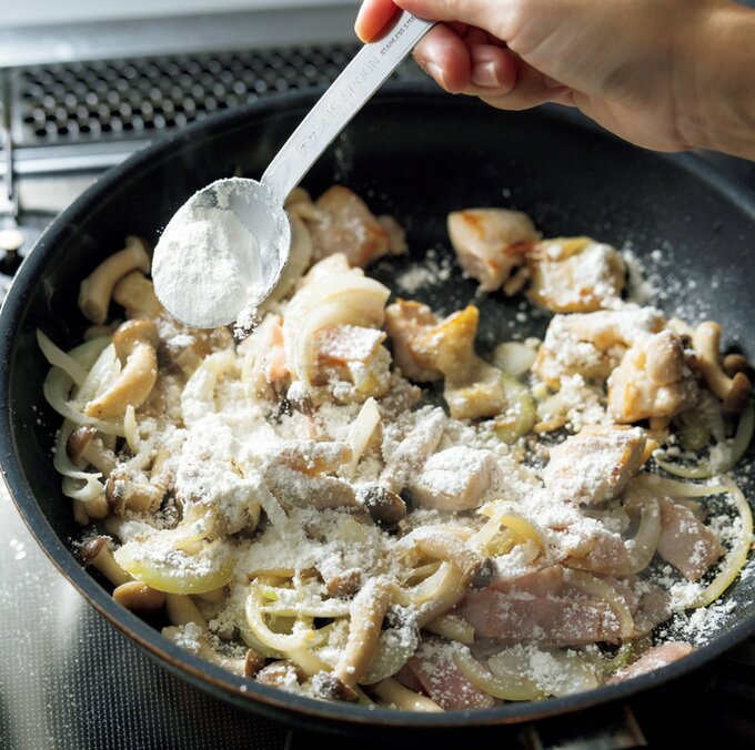 フライパンの中で具材に小麦粉をからめている様子