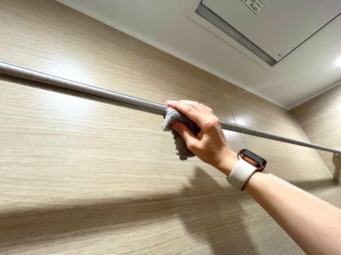 水アカがついた物干しポールを掃除している様子