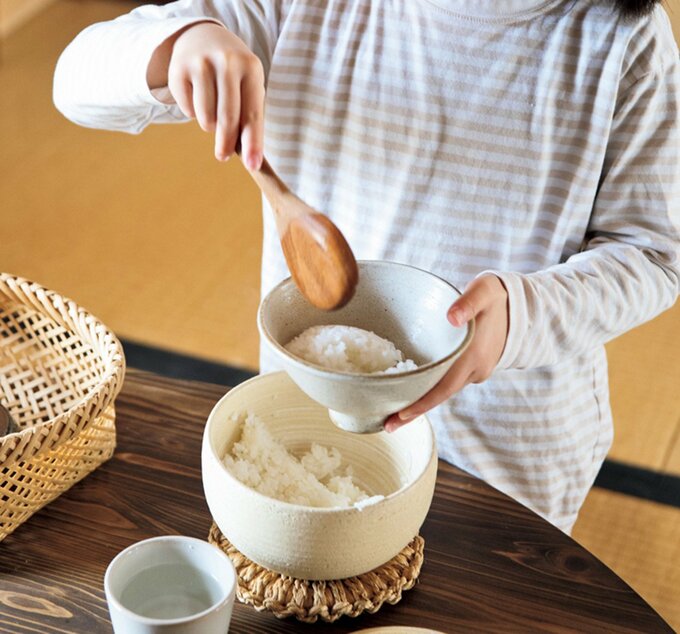 子どもがご飯を茶碗によそう様子