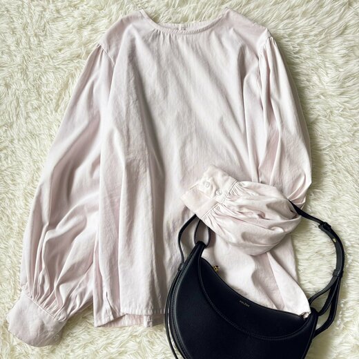 袖を曲げて、ハンドバッグを持たせているブラウス