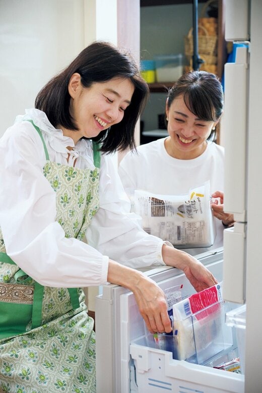にこやかな表情で冷凍庫に手を伸ばす女性二人