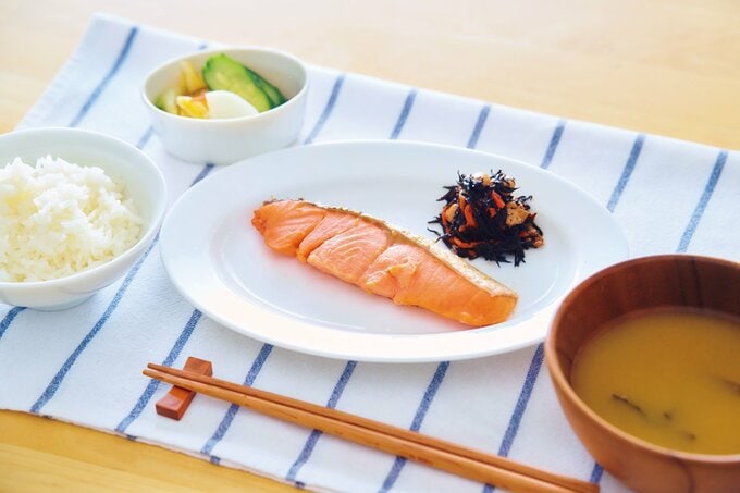 食卓に並ぶサケとみそ汁とご飯と漬物