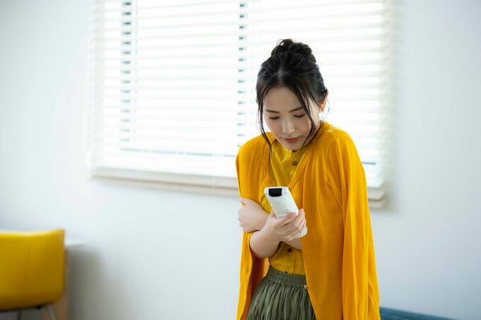 エアコンをつける女性