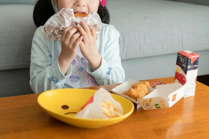 子どもがハンバーガーを食べている様子