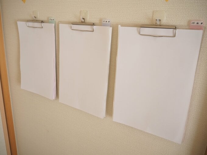 お便りをバインダーに壁かけている様子