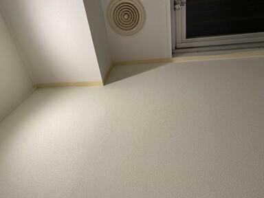 マスキングテープを隣接する壁や巾木に貼って養生した壁