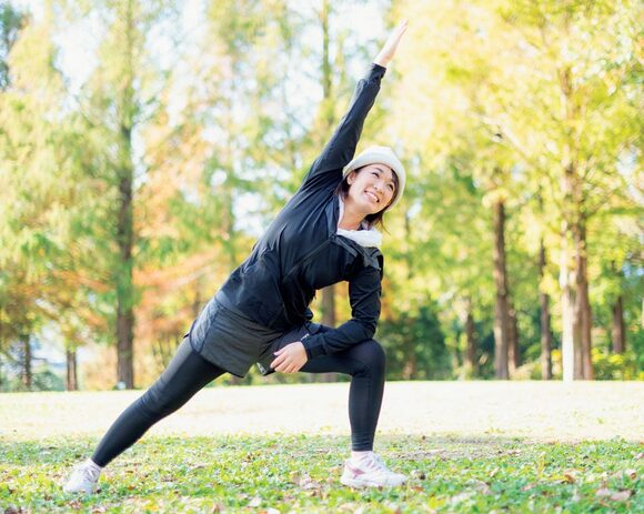 女性片足片手伸ばす