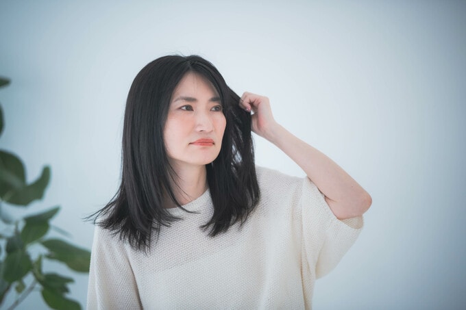 髪のうねりに悩む女性