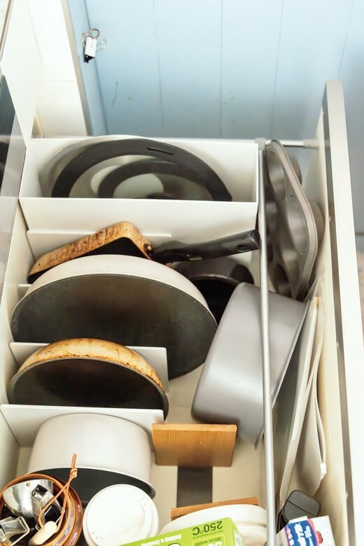 コンロ下の収納に並ぶフライパンやそのフタ