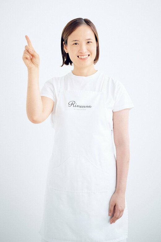 白Tシャツに白エプロンの女性が人差し指を立てている様子