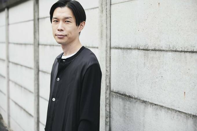 カベにもたれかかる男性