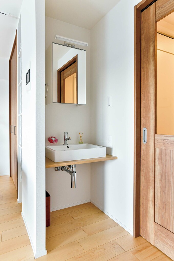 LDK 入り口脇に独立した洗面スペースを配置
