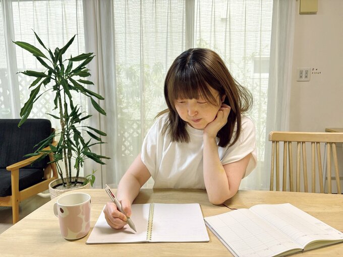 ノートに何かを書く女性