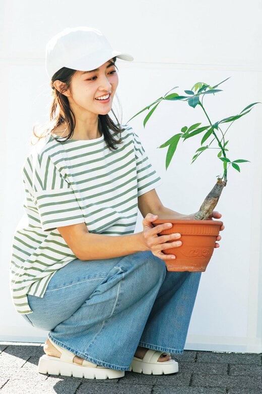 観葉植物を持ったボーダー服の女性