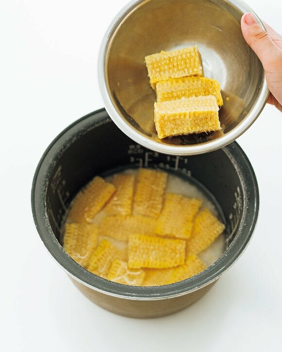 トウモロコシを炊飯器に入れる様子