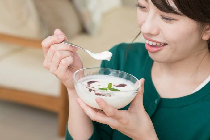 ヨーグルトを食べる女性
