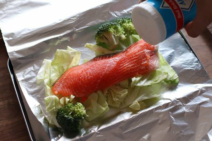 アルミホイルを広げて食材をのせ、調味料をふる様子