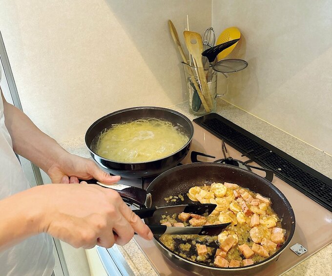フライパンと小鍋で料理をする様子