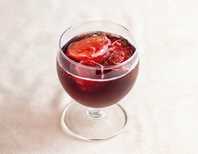 グラスに注いだピュアポム スパークリング レッドグレープジュース