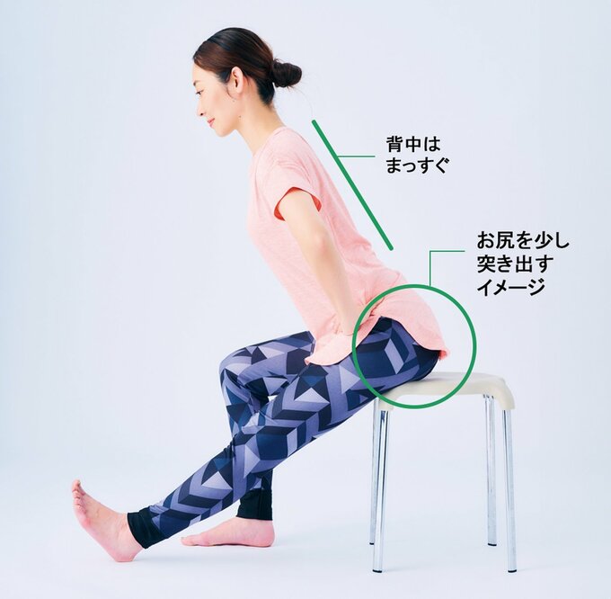 座ったまま骨盤を前に倒す女性