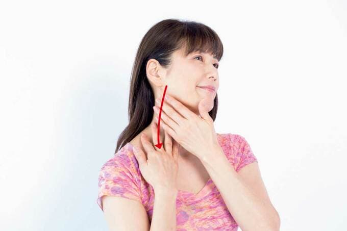 下あごのつけ根から鎖骨に向かってなでる様子