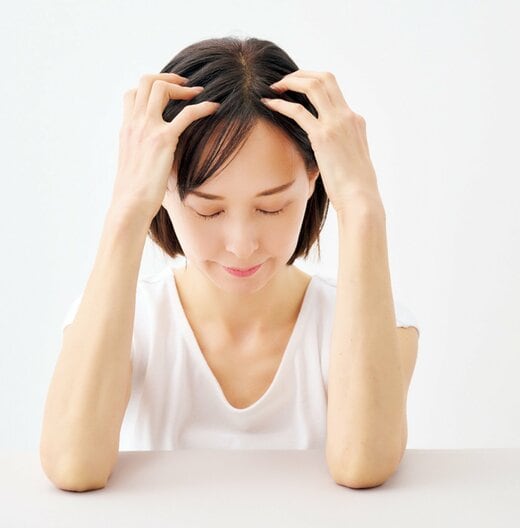 頭頂部下を押し上げる女性