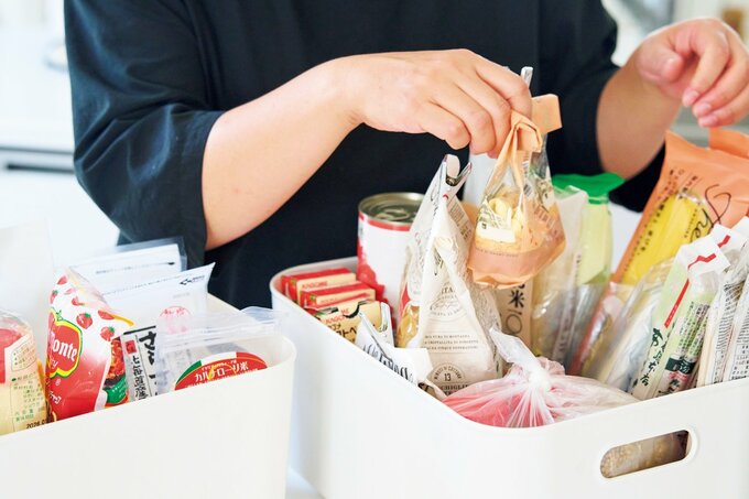 白いボックスにストックされた食材を整理する女性の手