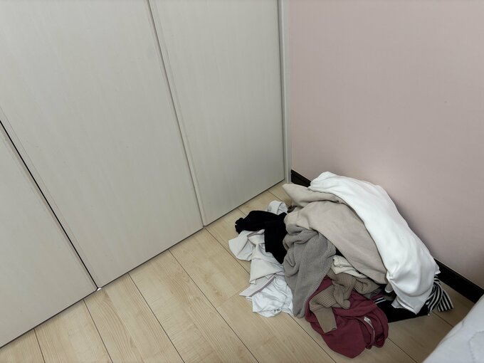 捨てる予定の服を部屋の隅に一旦置いておく