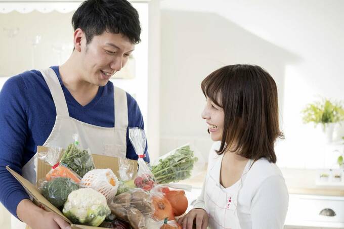 お野菜が入った箱を持つ男女