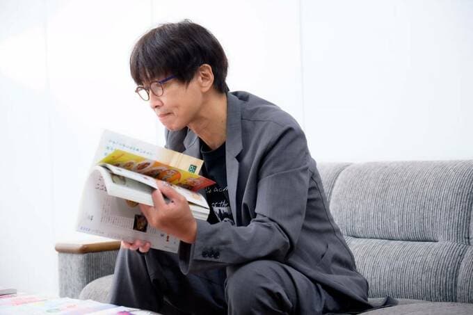 雑誌を持つ小林孝延さん