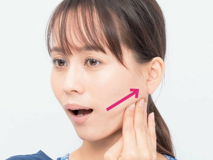 エラ付近に手を当てる女性