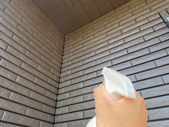 外壁にスプレーをかけている様子