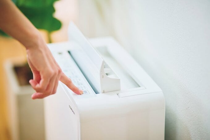 除湿器のスイッチを押す手元
