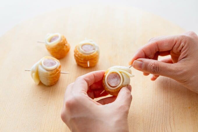 チーズとソーセージを巻いたちくわにつまようじを刺す