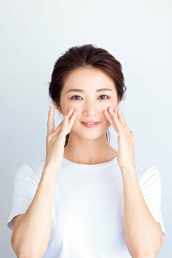 手で顔を触る女性