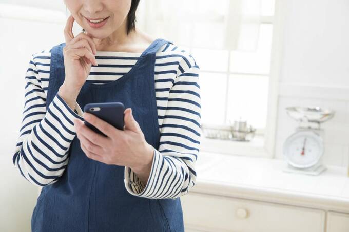 主婦がスマホを見ている様子