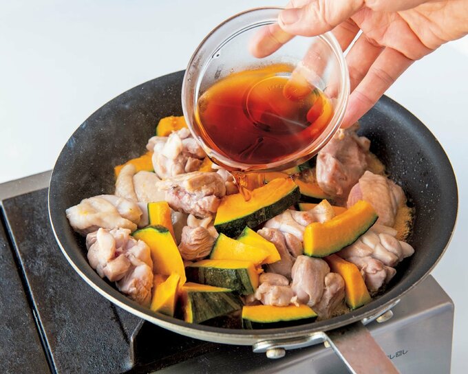 炒めた鶏肉にカボチャとこっくり酢を加える様子