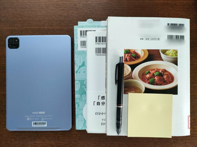 左は電子書籍を読む用のタブレット。右は現在家にある4冊の本