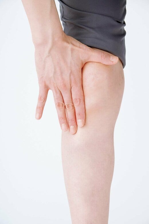 親指と人さし指をL字に広げて膝に沿わせる人