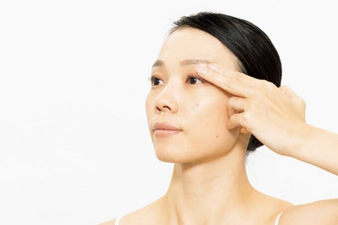 まぶたを押さえる女性