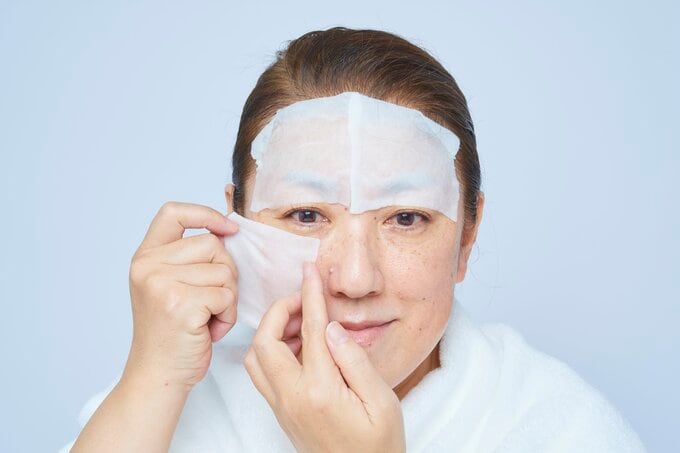 顔にコットンをのせる女性