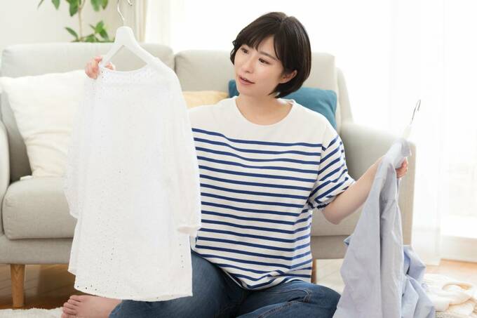 服を持つ女性