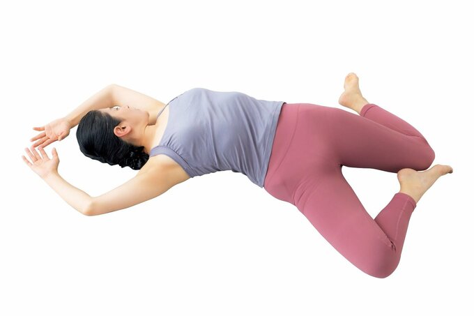 仰向けになって骨盤の左右差を整える女性