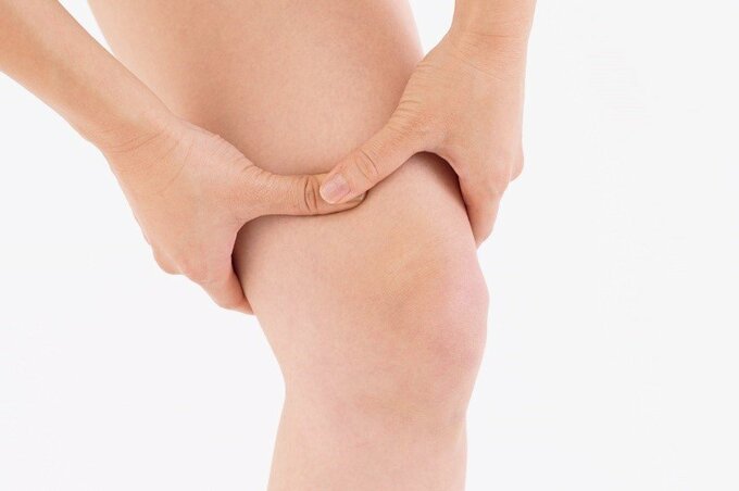 血海のツボを両手親指で押す様子